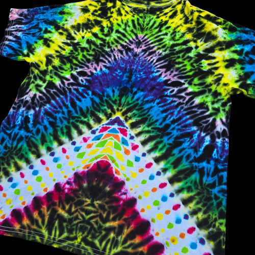 A short-sleeve tie-dye T-shirt laid flat on a black background, featuring a rainbow spiral pattern with a white lower section decorated with multicolored polka dots.