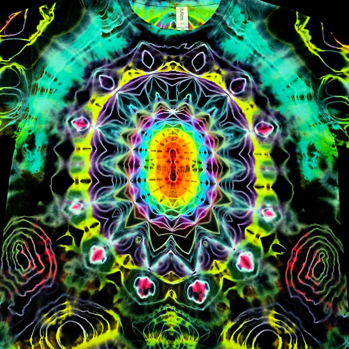 A close-up of a tie-dye t-shirt featuring a highly symmetrical, psychedelic mandala pattern with neon green, yellow, purple, blue, and pink colors on a black base.