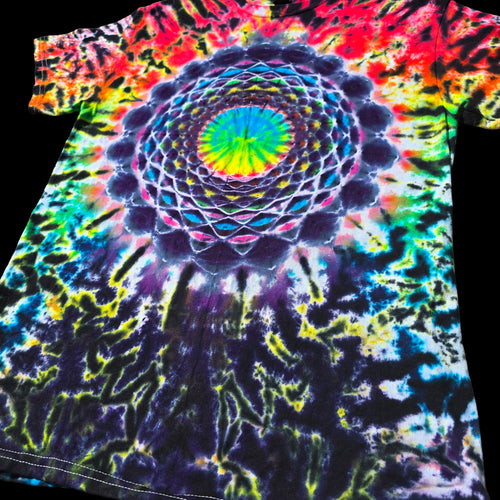 A short-sleeve tie-dye T-shirt laid flat on a black background, featuring a large central mandala-like spiral pattern with bright neon colors including blue, green, yellow, pink, purple, orange, and red.