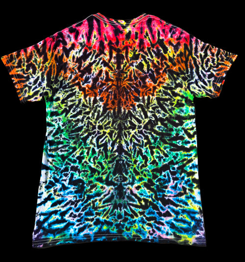 A short-sleeve crewneck t-shirt featuring a vibrant, symmetrical neon tie-dye pattern with a kaleidoscope of colors including pink, orange, yellow, green, blue, and purple on a black base, shown against a solid black background.