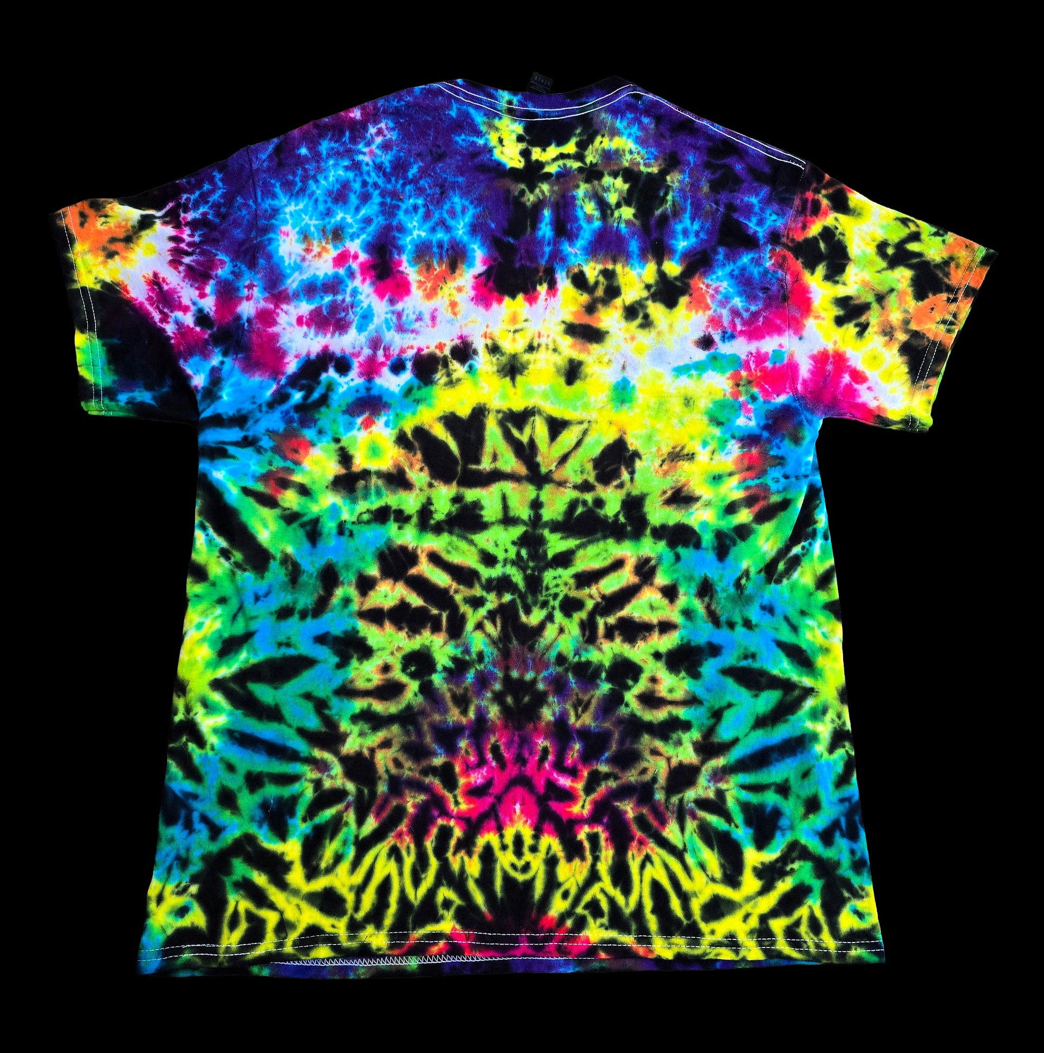 A short-sleeve crewneck t-shirt featuring a vibrant, symmetrical tie-dye pattern in neon colors, displayed flat against a solid black background.