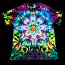 A short-sleeve crewneck t-shirt featuring a vibrant, multicolor psychedelic tie-dye pattern with a large symmetrical mandala design on the front, displayed flat against a solid black background.