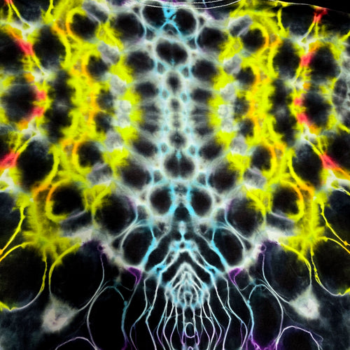A close-up of a tie-dye fabric pattern with a symmetrical, kaleidoscopic design featuring black, neon yellow, light blue, red, and purple colors.