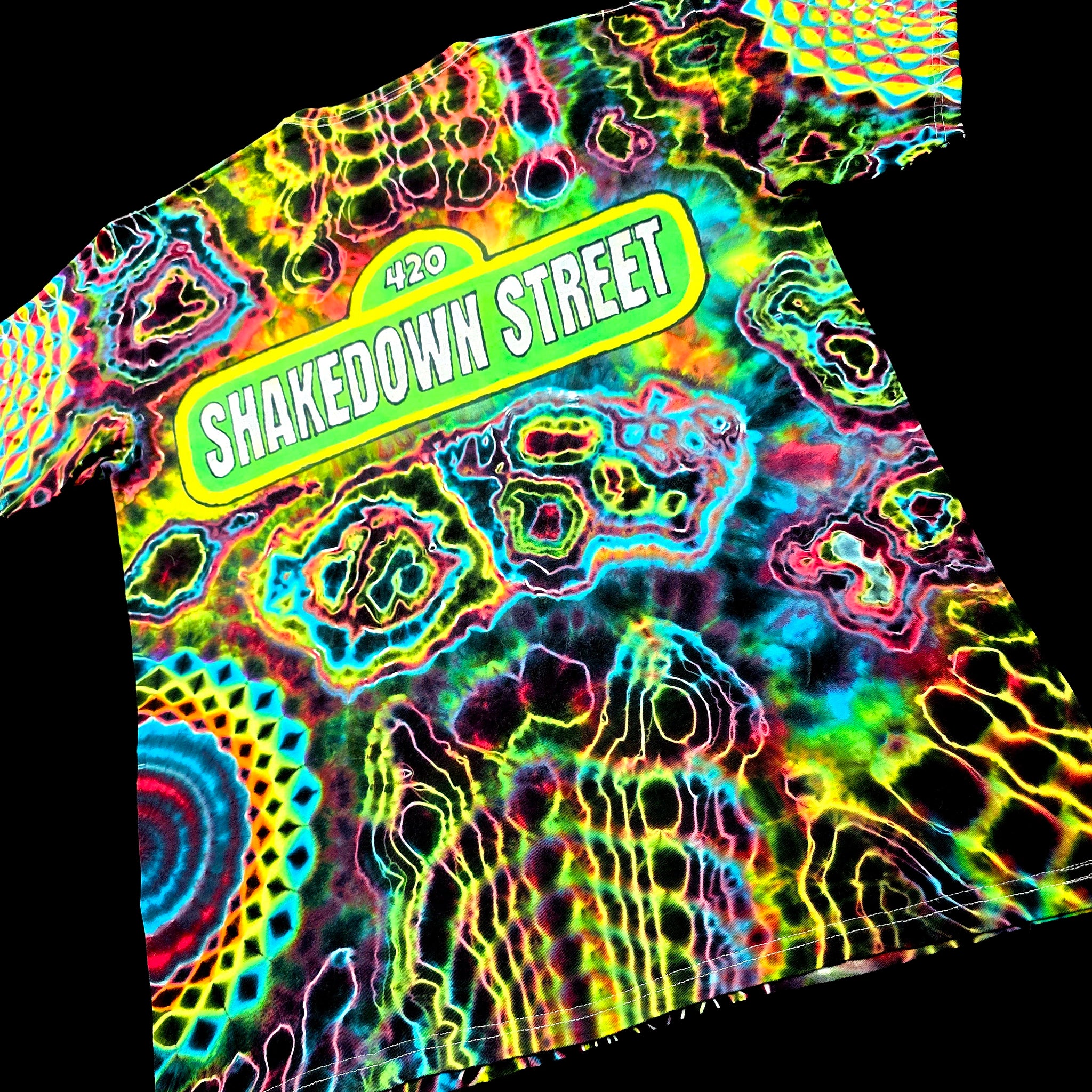 Back angled perspective of tie dye tee detailing Grateful Dead Shakedown Street street sign art and colorful agate formations