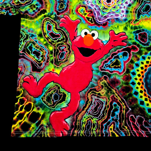 Close up macro view of hand painted Elmo face with orange nose and wide smile on tie dye background