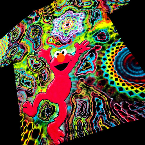 Front angled perspective view of tie dye shirt showing bright red Elmo graphic, geometric star, and side mandala pattern