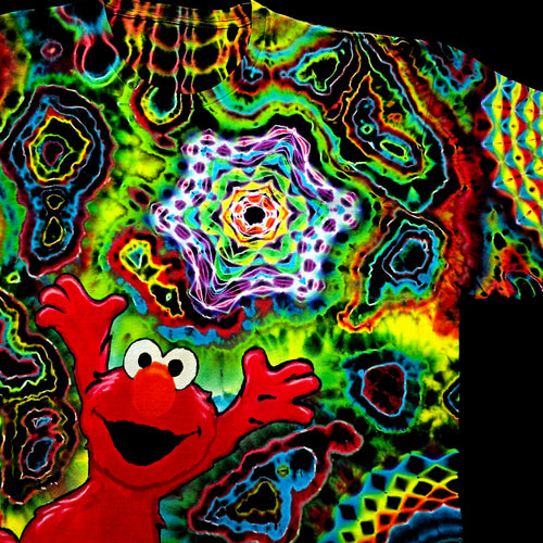 A close-up of a highly colorful tie-dye shirt featuring a red cartoon character with raised hands and a psychedelic kaleidoscopic pattern in neon green, blue, yellow, purple, and red.