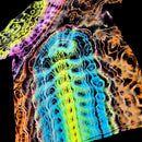A close-up of a tie-dye or batik-printed fabric with a highly abstract, wavy pattern in multiple neon colors including blue, green, yellow, orange, pink, and purple on a black background.