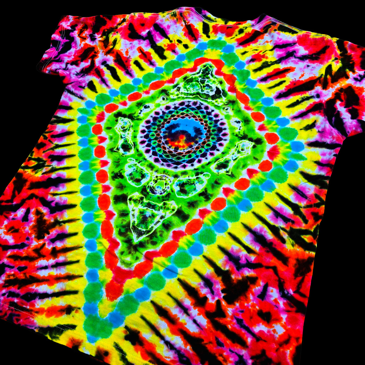 A vibrant tie-dye t-shirt featuring a psychedelic spiral pattern with concentric rings of green, blue, red, and yellow radiating from the center, set against a solid black background.