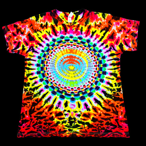 A short-sleeve crewneck t-shirt featuring a vibrant, psychedelic tie-dye pattern with a central mandala design. The shirt is covered in neon colors including pink, yellow, green, blue, orange, and purple in a symmetrical, radial burst pattern, presented flat against a solid black background.