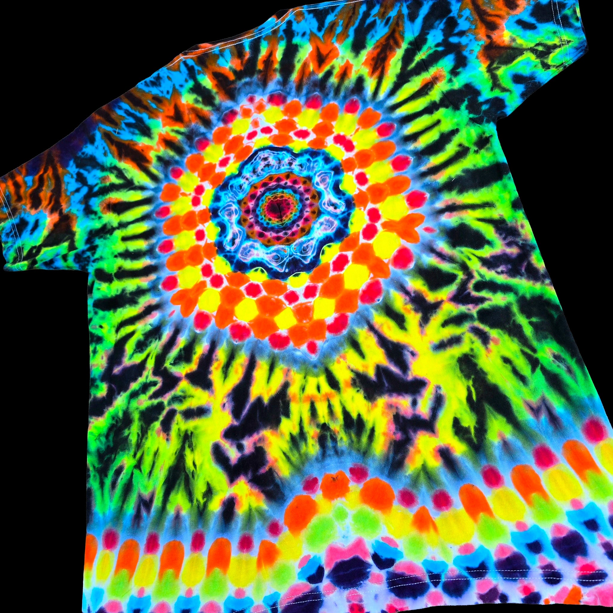 A short-sleeve tie-dye T-shirt with a vibrant psychedelic spiral pattern in neon green, yellow, orange, red, blue, and purple on a black background.