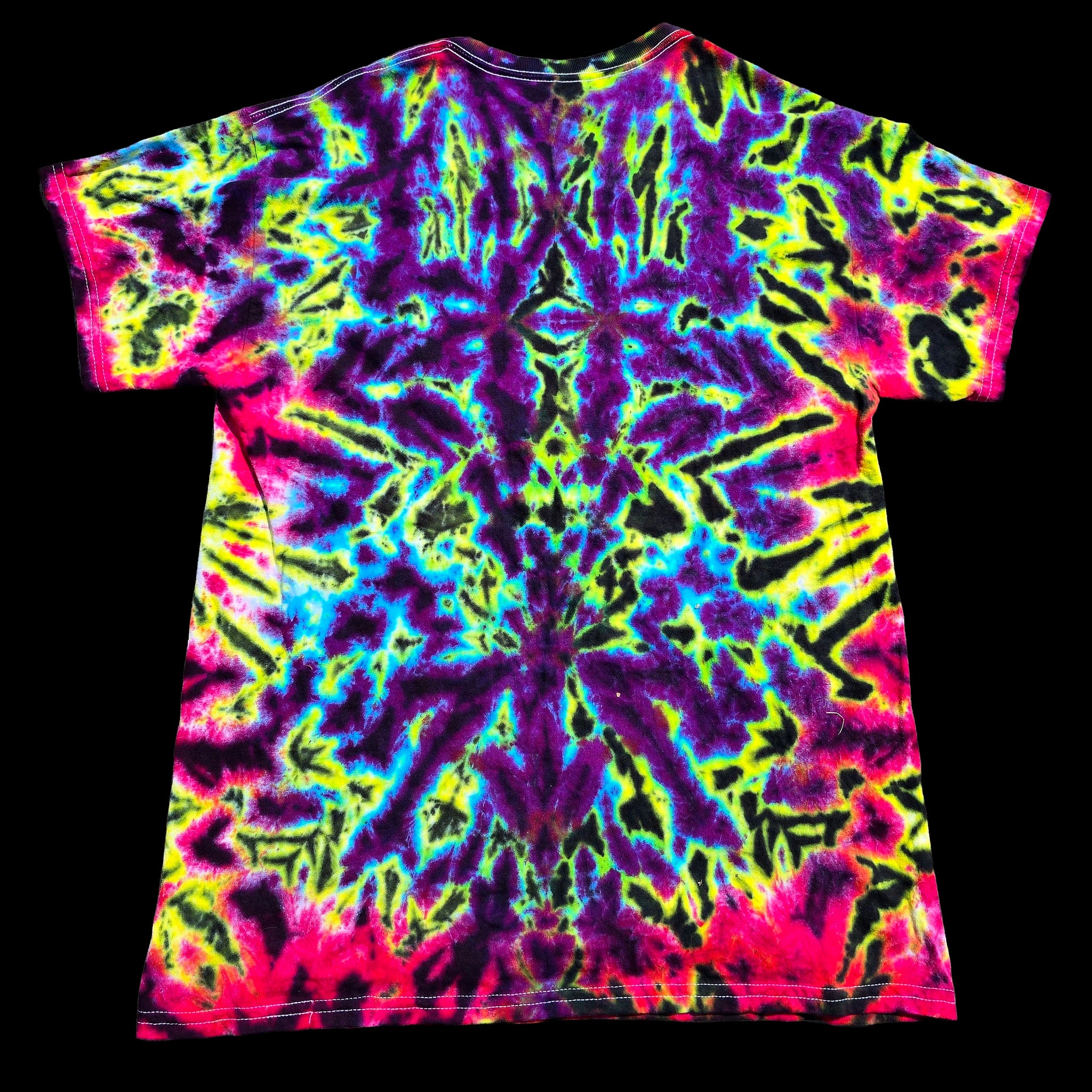 A short-sleeve crewneck t-shirt featuring a vibrant, symmetrical neon tie-dye pattern with purple, pink, yellow, blue, and green on a black background.