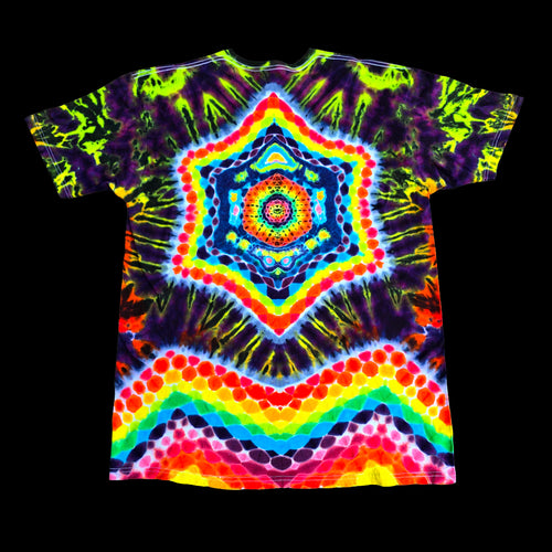 A short-sleeve tie-dye T-shirt laid flat against a solid black background, featuring a highly symmetrical, psychedelic mandala design with neon green, yellow, orange, red, blue, and purple patterns.