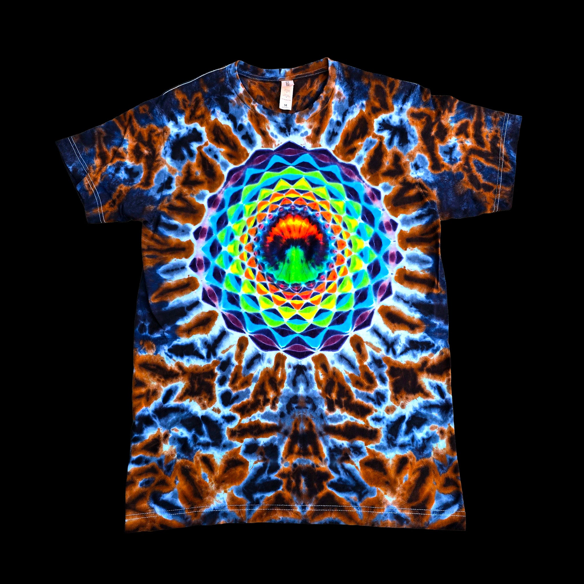 A short-sleeve crewneck t-shirt featuring a vibrant, symmetrical mandala design with a rainbow spiral pattern over a blue and orange tie-dye background.