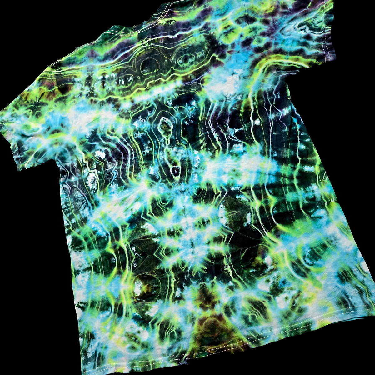 A short-sleeve crewneck t-shirt featuring a vibrant, psychedelic tie-dye pattern with swirling waves of neon green, cyan blue, lime yellow, and black, shown against a solid black background.