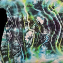 A close-up of a tie-dye fabric with a wavy, psychedelic pattern in shades of teal, green, black, purple, and white.