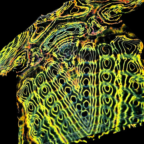 A close-up of a garment featuring an abstract, high-contrast wavy pattern in neon yellow, green, orange, and blue over a black base, shown against a solid black background.