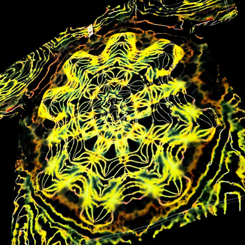 A close-up of a garment featuring a highly detailed, symmetrical neon yellow and green abstract pattern over a black base, with a small white label visible near the top.