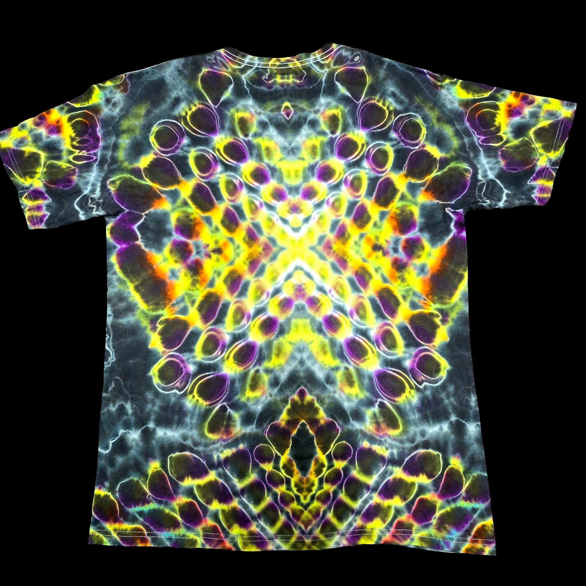 A short-sleeve crewneck t-shirt featuring a vibrant, symmetrical psychedelic tie-dye pattern with neon yellow, purple, green, and orange bubble motifs on a black base, shown flat against a solid black background.