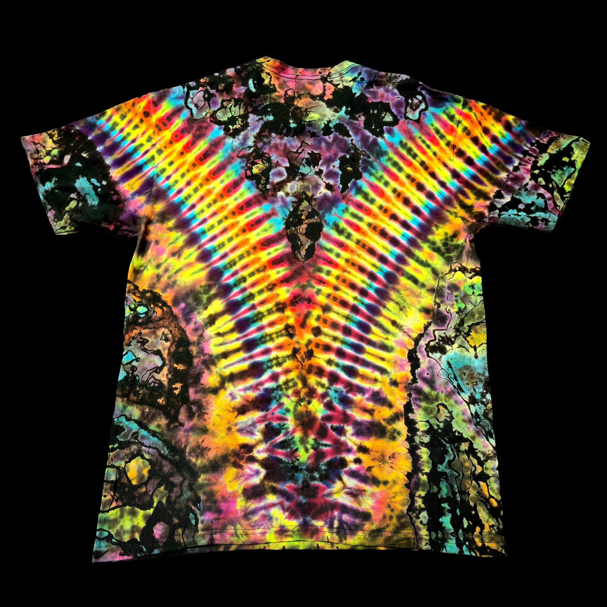 A short-sleeve tie-dye t-shirt with a vibrant, symmetrical rainbow pattern radiating from the center, shown flat against a solid black background.
