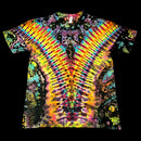 A short-sleeve crewneck tie-dye t-shirt featuring a vibrant, symmetrical psychedelic pattern with radiating rainbow stripes and dark organic splatters, shown flat against a solid black background.