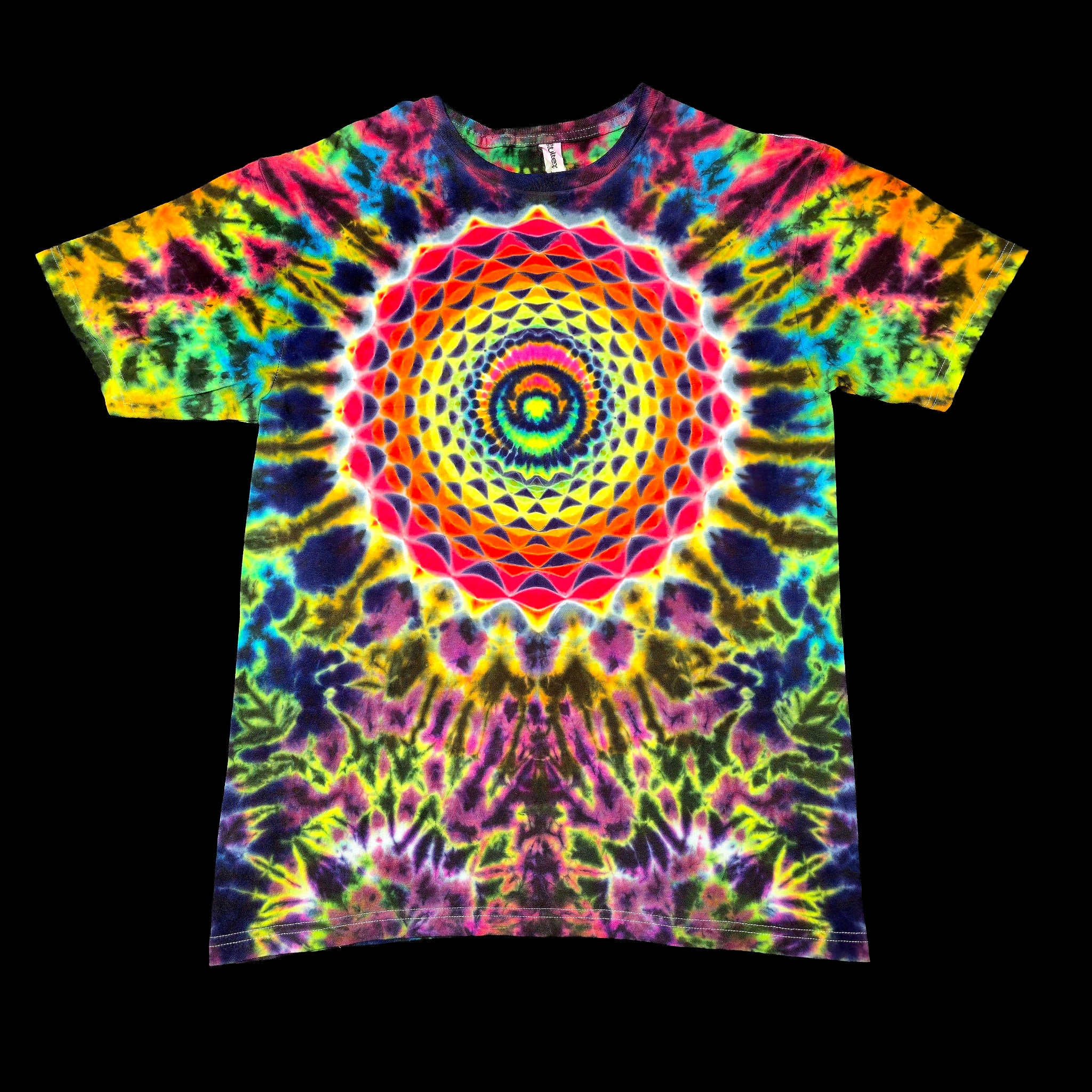 A short-sleeve crewneck tie-dye t-shirt featuring a large, symmetrical mandala design in a rainbow of neon colors including pink, yellow, green, blue, and purple, displayed flat against a solid black background.