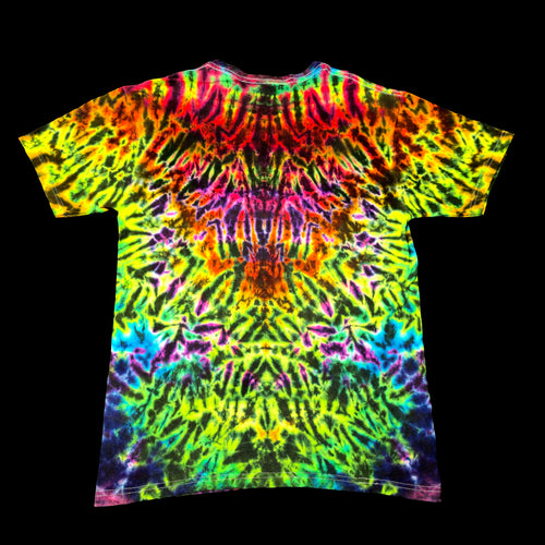 A short-sleeve crewneck t-shirt featuring a vibrant, symmetrical tie-dye pattern with neon green, yellow, pink, orange, purple, and blue colors radiating from the center, shown against a solid black background.