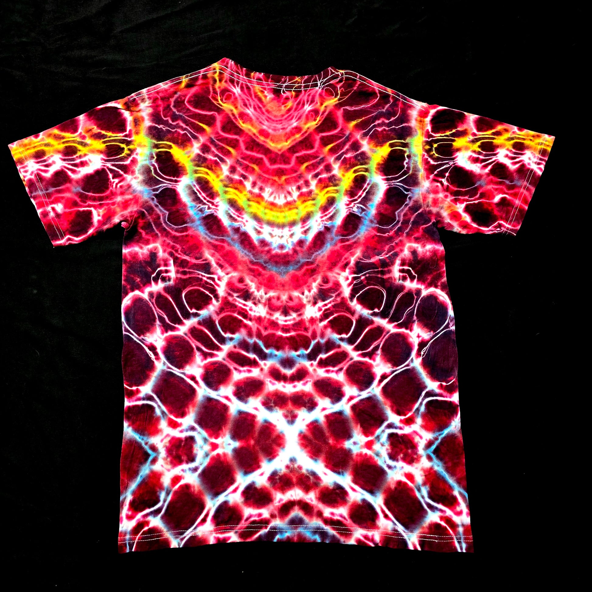 back view of handmade tie-dye shirt showing symmetrical Hyper X and Cosmic Egg patterns with heart-inspired flow