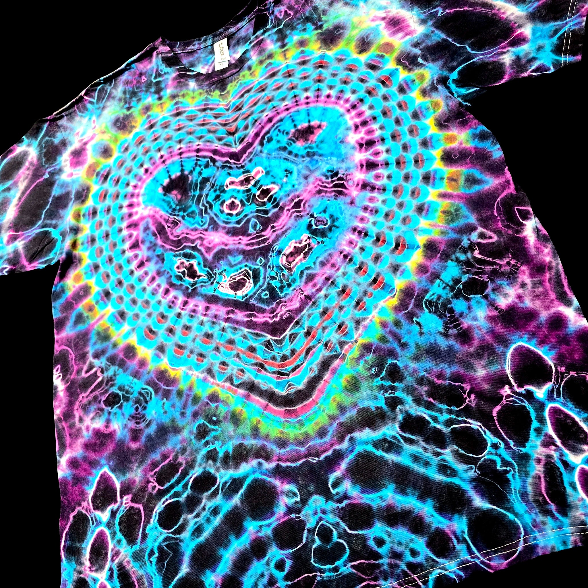 A black short-sleeve t-shirt featuring a vibrant, multicolor tie-dye pattern with a large heart design in the center and bubble-like patterns on the lower half, set against a solid black background.