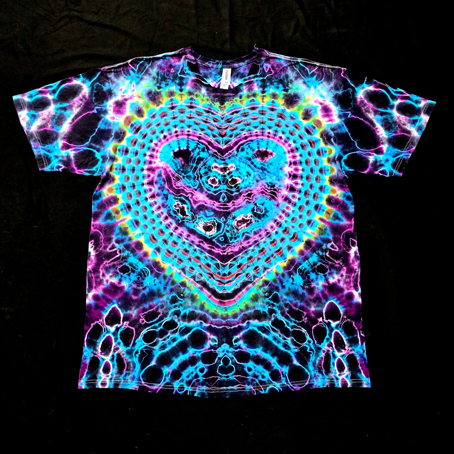 Front view of handmade heart tie-dye shirt featuring neon cyan and magenta heart mandala on black cotton
