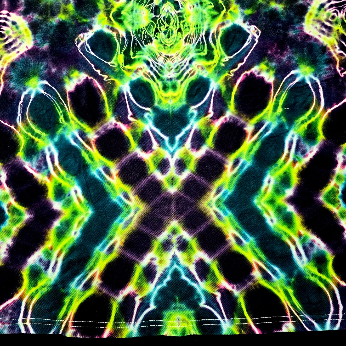 Abstract tie-dye pattern with green, blue, and black colors on a dark background