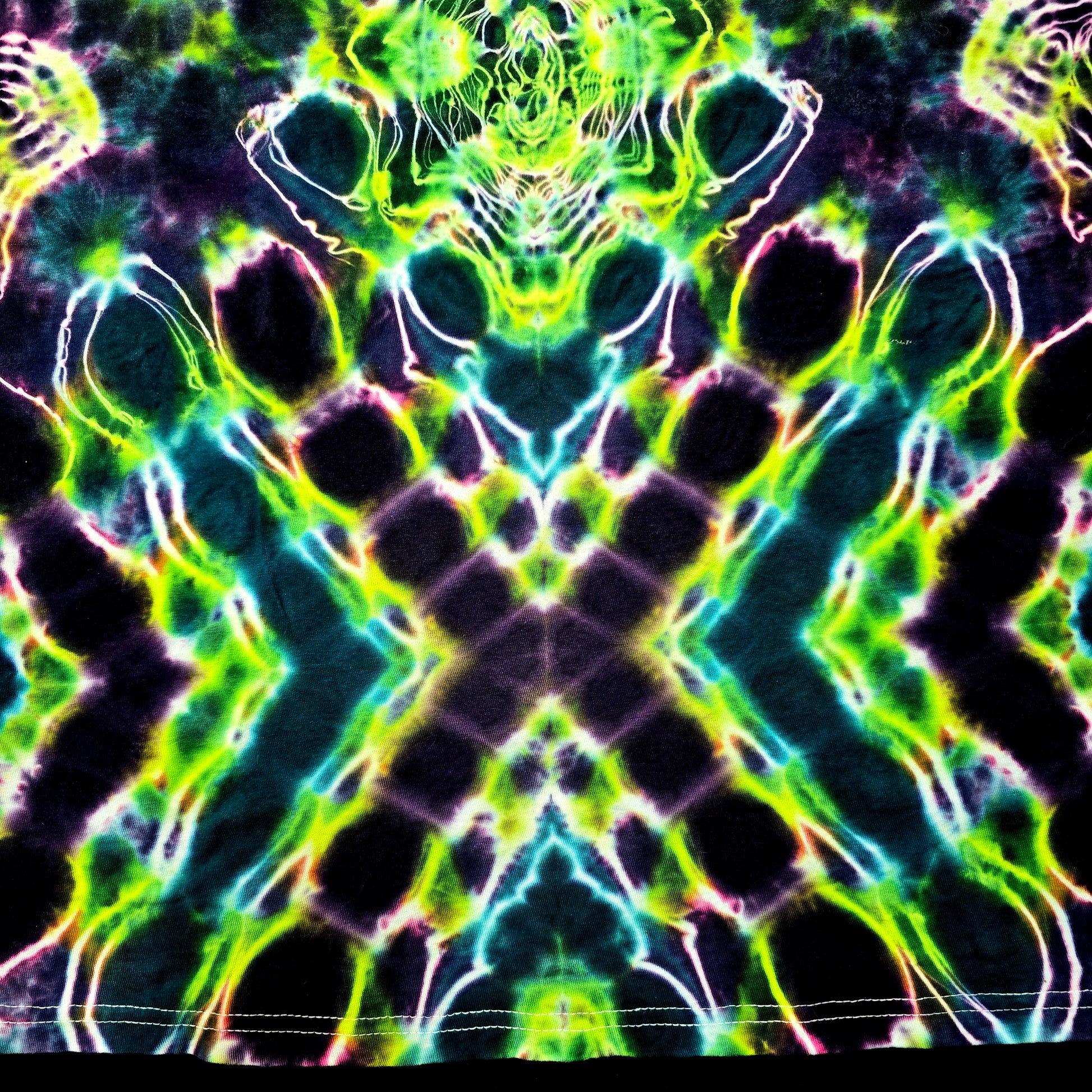 Abstract tie-dye pattern with green, blue, and black colors on a dark background