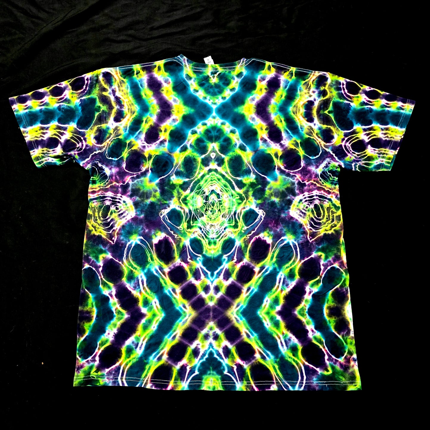 One-of-one handmade tie-dye shirt featuring bold X-shaped symmetry in green and blue, back view