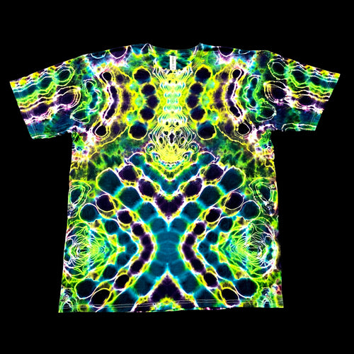 A short-sleeve crewneck t-shirt featuring a vibrant, symmetrical neon psychedelic pattern with green, yellow, blue, and purple tie-dye effects, displayed flat against a solid black background.