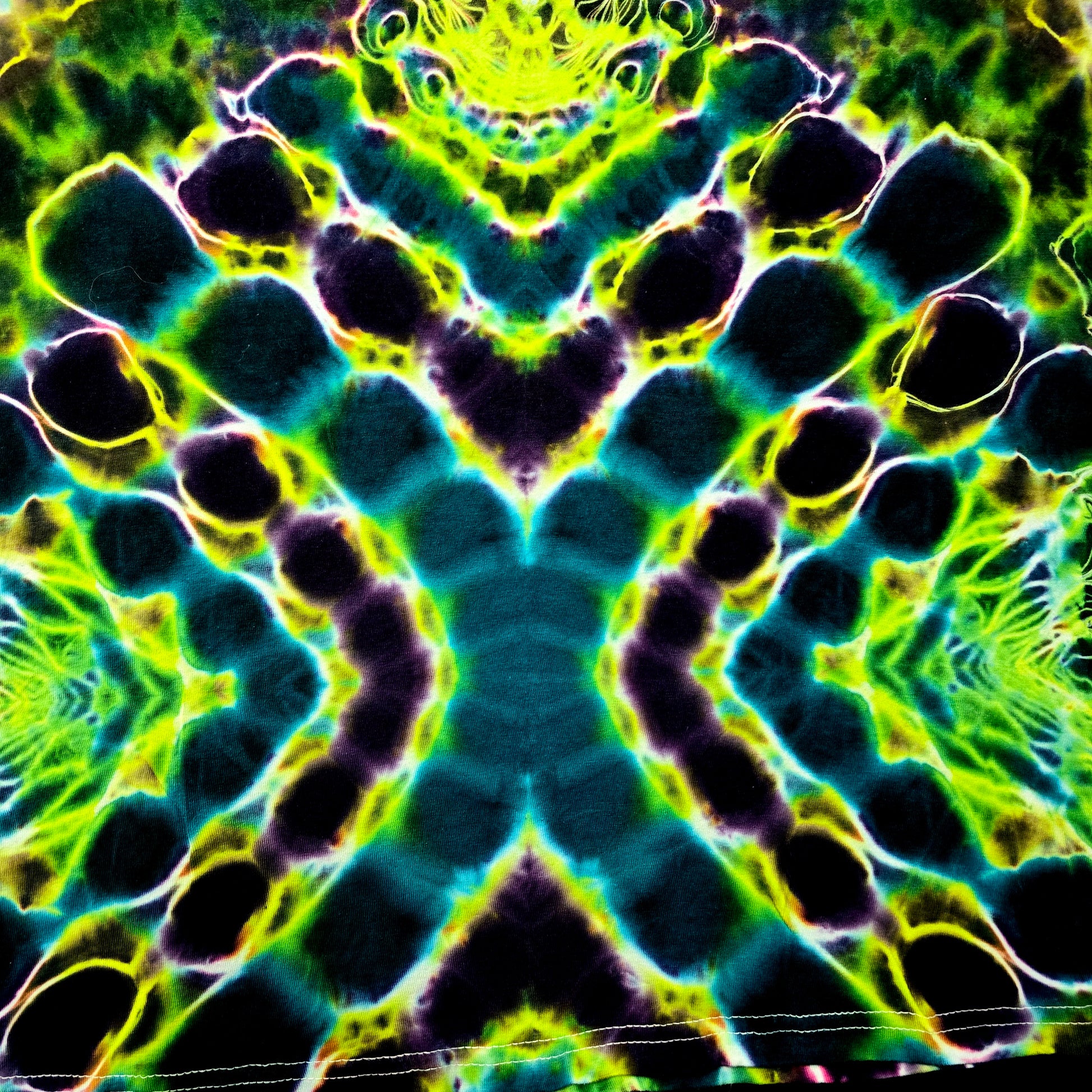 Colorful tie-dye pattern with green, blue, and purple hues.