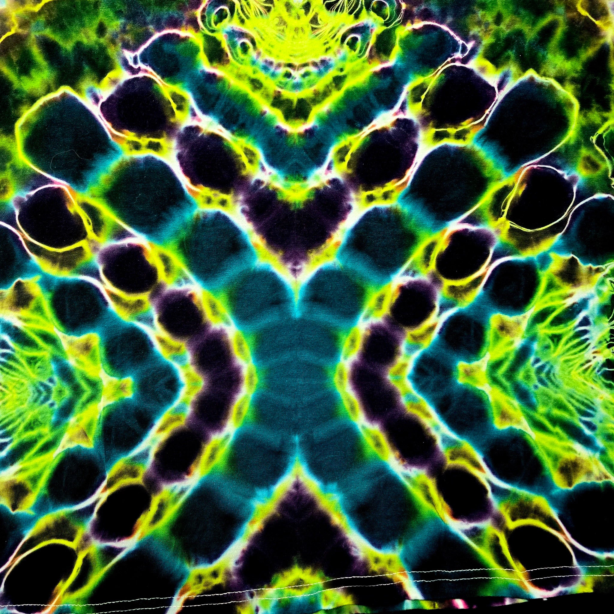 A symmetrical, kaleidoscopic abstract pattern with neon green, yellow, blue, and black organic shapes arranged in a mirrored geometric design.