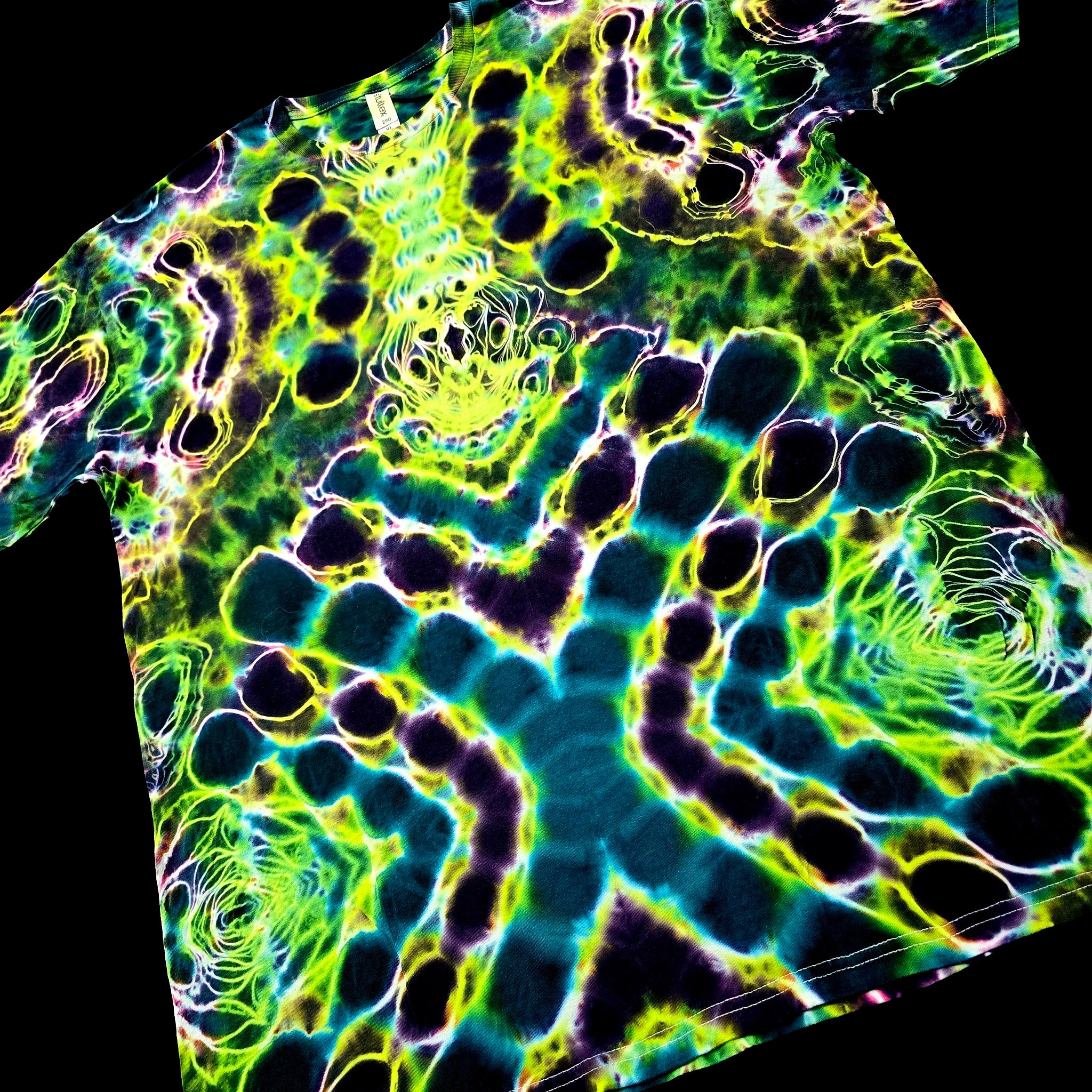 Angled front view of handmade tie-dye tee showing electric green and teal color flow