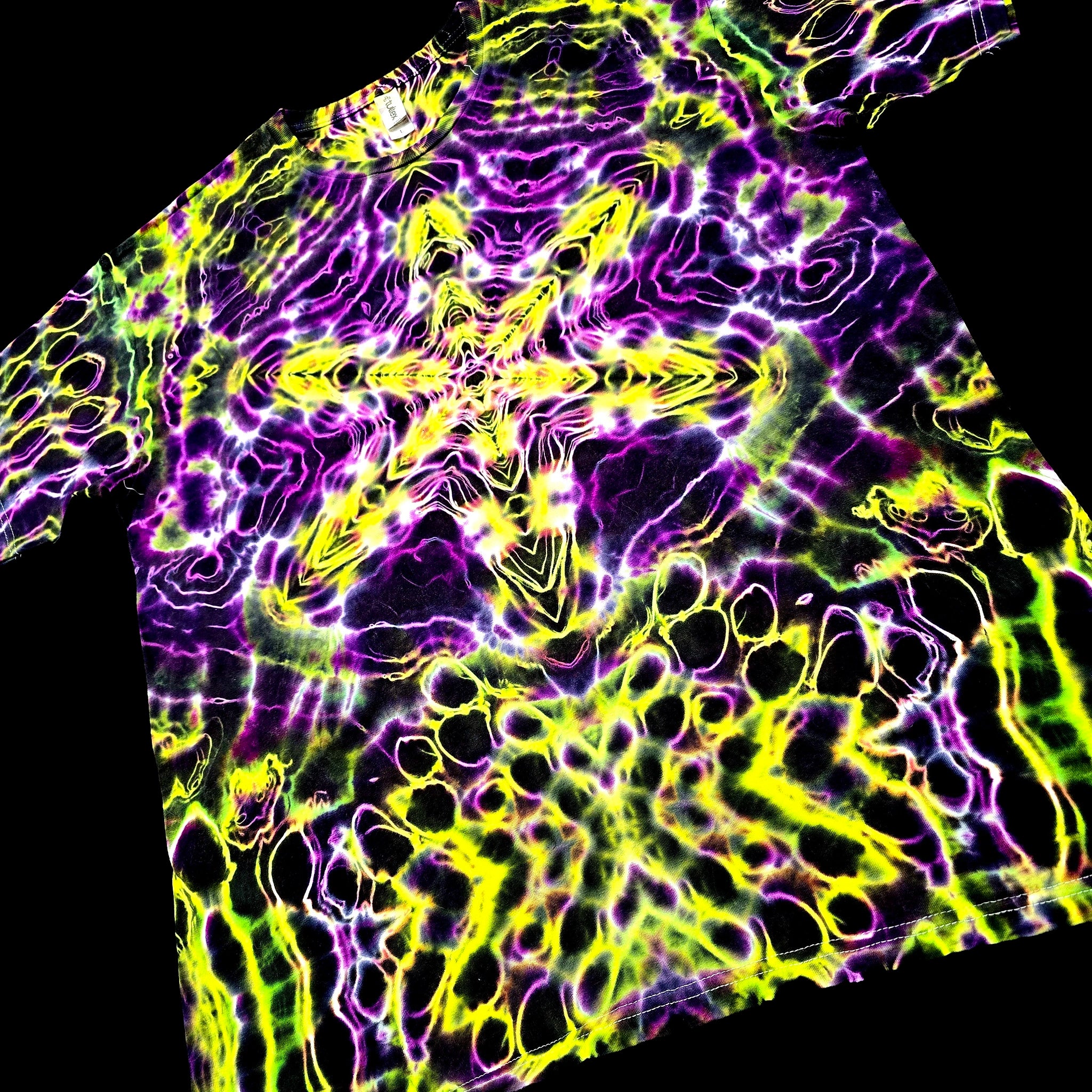 Tie-dye shirt with vibrant purple and yellow patterns on a black background