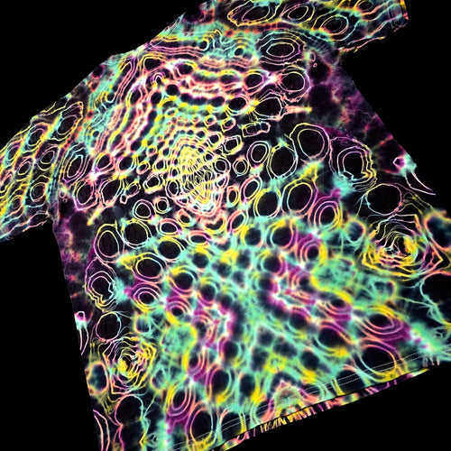 A short-sleeve t-shirt with a vibrant, psychedelic tie-dye pattern featuring concentric circles and wavy lines in neon pink, yellow, green, and purple over a black base, shown against a solid black background.