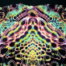 A close-up of a tie-dye t-shirt featuring a highly symmetrical, psychedelic pattern with neon pink, yellow, green, and blue outlines on a black base.