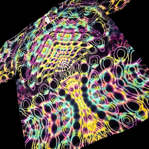 A short-sleeve tie-dye T-shirt laid flat on a black background, featuring a dense neon pattern of pink, yellow, green, and blue wavy lines over a dark base.