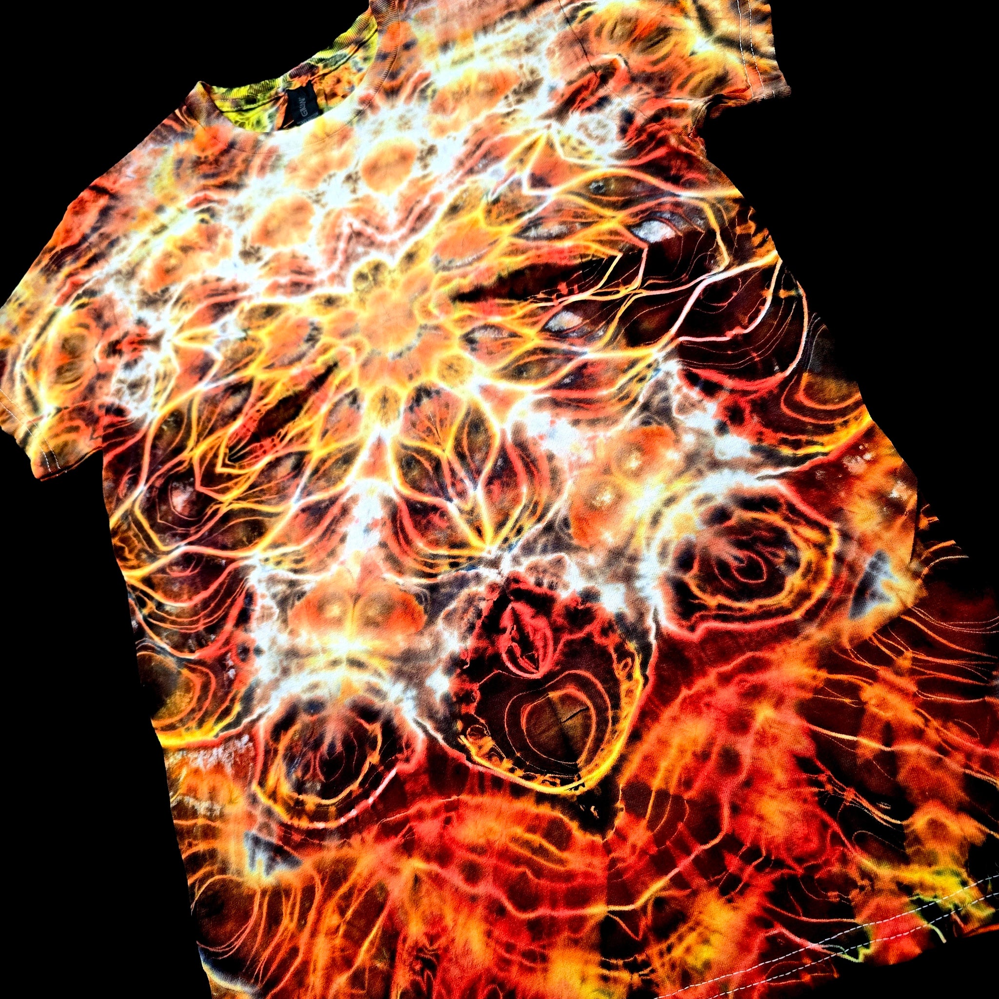 Angled front view of handmade tie-dye tee emphasizing the spine-like symmetry and flowing electric dye textures
