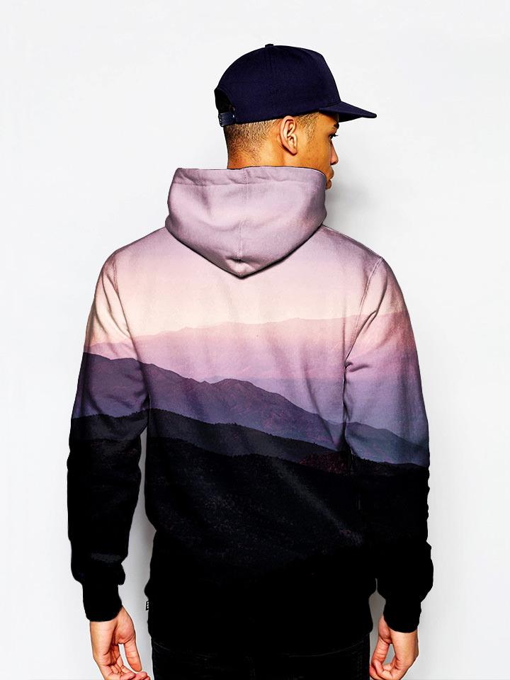 Model in mountain sunrise landscape all over print pullover hoodie